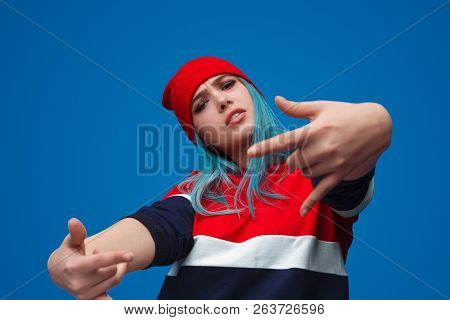 From Below Shot Of Modern Hip-hop Trendy Woman Showing Rock-and-roll Gesture And Looking Provocative