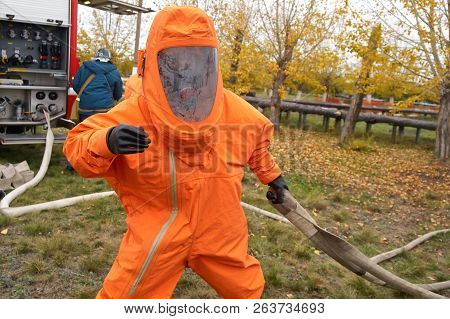 A Man Works In An Orange Chemical Protection Suit. Chemical Hazards.