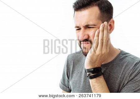 Sad Bearded Young Man Standing And Having Toothache On White Background