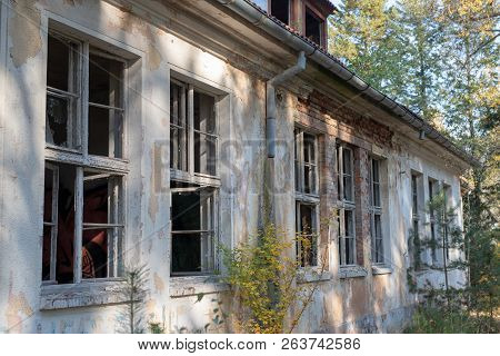 A Broken Window In An Old Abandoned Building. Broken Glass On The Window Site. Old Building.