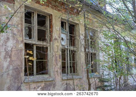 A Broken Window In An Old Abandoned Building. Broken Glass On The Window Site. Old Building.