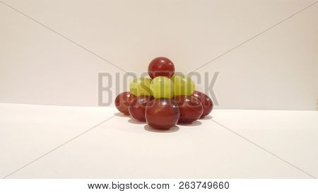 Mixed Grapes Stacked Into A Pyramid On White Background.