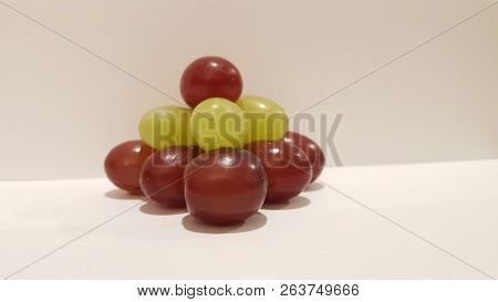 Mixed Grapes Stacked Into A Pyramid On White Background.