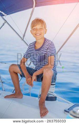 Little Boy On Board Of Sailing Yacht On Summer Cruise. Travel Adventure, Yachting With Child On Fami