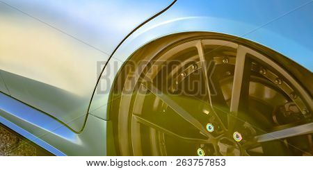 Blue Car With Black Tire Rim And Blue Bolt Caps