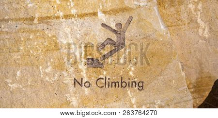 No Climbing Sign Engraved On Brown Rock