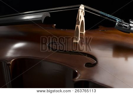 Close Up Of A Cello And A Bow Set Against A Black Background