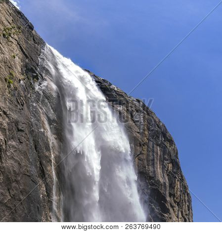 Yosemite Falls Plunging Down A Cliff Against Sky