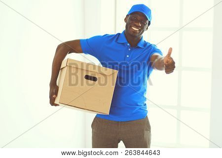 Portrait Of An Handsome Happy Deliverer With Box