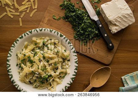 Turkish Noodle / Eriste With Cheese And Parsley On A Wooden Surface.