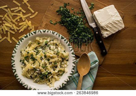 Turkish Noodle / Eriste With Cheese And Parsley On A Wooden Surface.