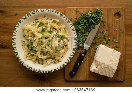 Turkish Noodle / Eriste With Cheese And Parsley On A Wooden Surface.