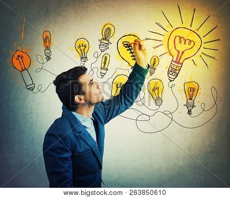 Thoughtful Businessman Drawing Imaginative Shining Light Bulbs. Different Business Thinking, Genius 