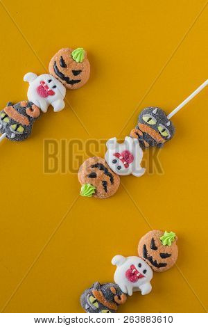 Halloween Candies Arranged In An Alternating Pattern On An Colored Background