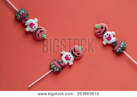Halloween Candies Arranged In An Alternating Pattern On An Colored Background