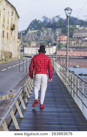 Unrecognizable Sporty Man Walking Along Riverside Of Duoro River At Porto, Portugal.