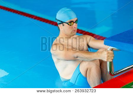 Photo of athlete swimmer man at side in pool