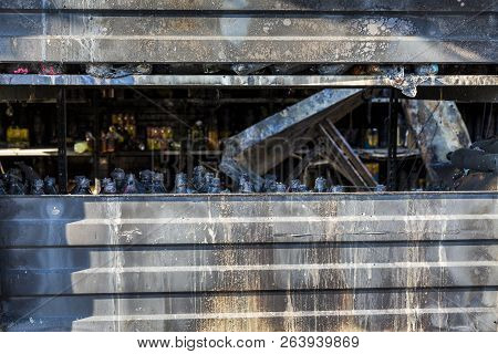 Close Up Damaged Industry Supermarket Metallic Facade After Arson Fire With Burn Debris Of Beer Bott