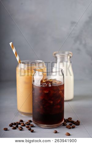 Cold Brew Iced Coffee In A Glass With Milk Or Creamer On Gray Background With Copy Space