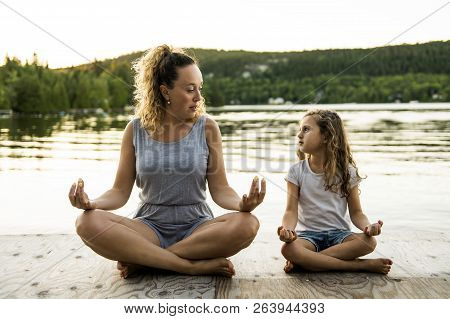 Happy Family Mother And Child Daughter Doing Yoga