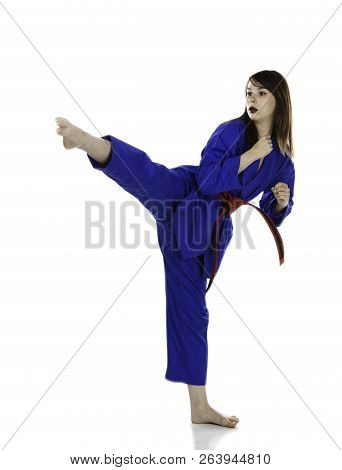 Female Red Belt Student Practicing Tae Kwon Do Martial Arts Moves In A Blue Dobok Or Gi (uniform) Is