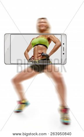Sporty Muscular Woman Doing Squats, Focus On Belly. Conceptual Image With A Smartphone, Demonstratio