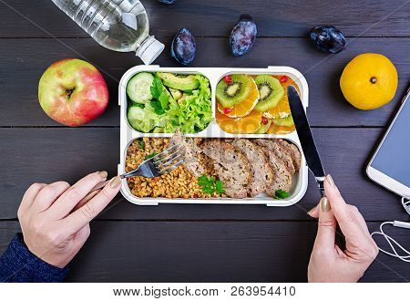 Top View Showing Hands Eating Healthy Lunch With Bulgur, Meat And Fresh Vegetables And Fruit On A Wo