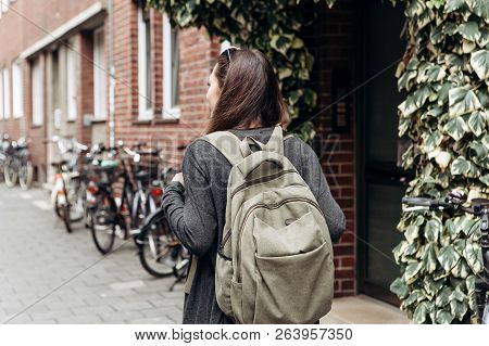 Tourist With A Backpack Is Looking For Booked Online Accommodation In An Unfamiliar City. Or A Stude