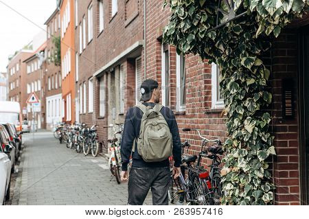 Tourist With A Backpack Is Looking For Booked Online Accommodation In An Unfamiliar City