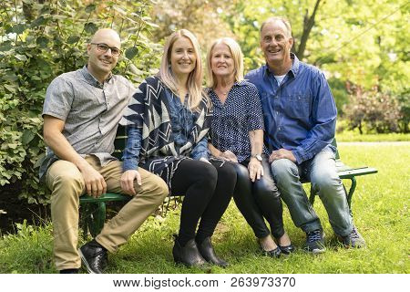 A Family Sit On Bench A Autumn Season