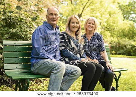 A Family Sit On Bench A Autumn Season