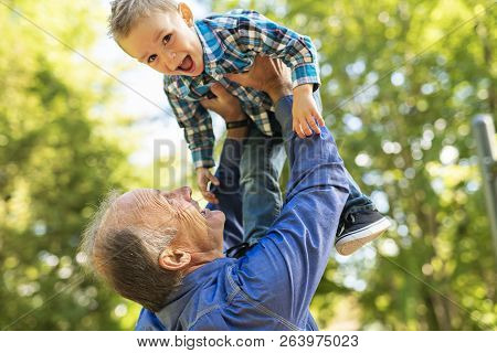 Grandfather And Littleson Having Fun In The Park