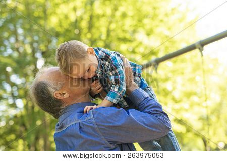 Grandfather And Littleson Having Fun In The Park