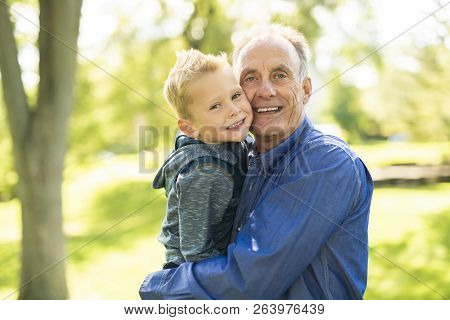 Grandfather And Littleson Having Fun In The Park