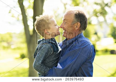 Grandfather And Littleson Having Fun In The Park