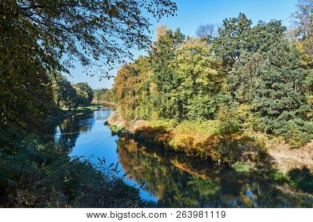 Trees On The Banks Of The Nysa Łużycka During Autumn On The Border Between Poland And Germany