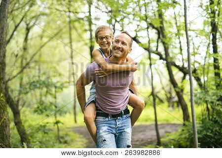 Father Giving His Son A Piggyback Ride, Having Fun