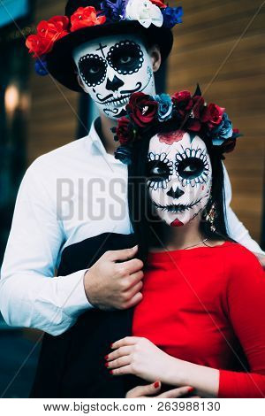 A Couple, Wearing Skull Make-up For. All Souls Day. Boy And Girl Sugar Skull Makeup.painted For Hall