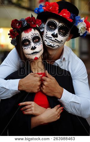 A Couple, Wearing Skull Make-up For. All Souls Day. Boy And Girl Sugar Skull Makeup.painted For Hall