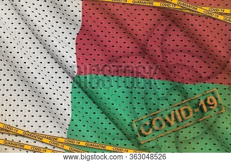 Madagascar Flag And Covid-19 Biohazard Symbol With Quarantine Orange Tape And Stamp. Coronavirus Or 
