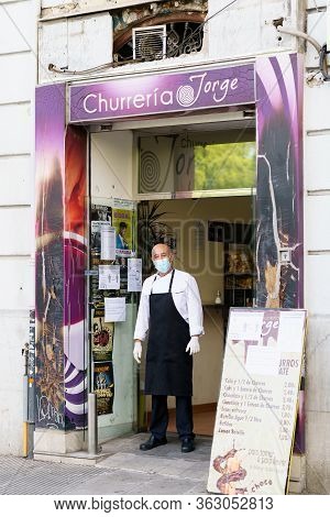 Granada, Spain, 23rd April, 2020 Cooking A Churro Shop Standing In The Doorway Of His Shop, Wearing 