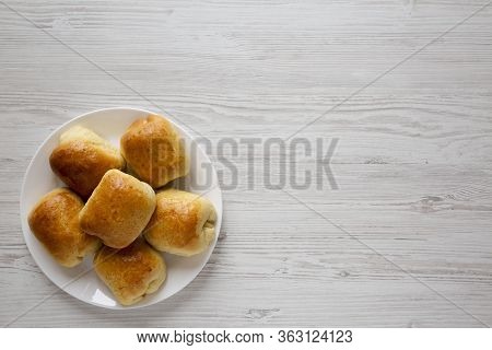 Home-baked Beef Russian Bierocks On A White Plate On A White Wooden Surface, Top View. Flat Lay, Ove