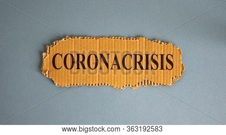 Word Coronacrisis On The Piece Of Cardboard On Blue Fon.