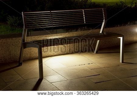 View Of A Bench On The Sidewalk In Siofok, Hungary During The Night
