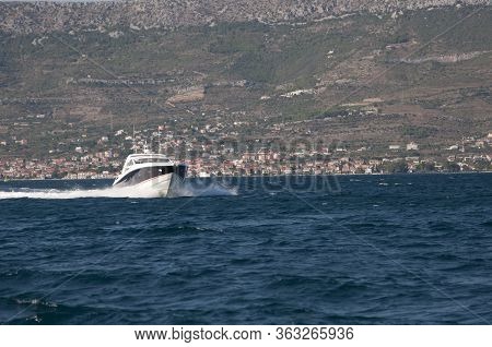 Motorboat In The Mediterranean Sea Against The Background Of Rocks And Mountains