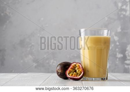 Fruit Protein Shake On A White Wooden Table. Fresh Milkshake With Passion Fruit. A Glass Of Protein