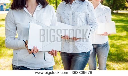 Young Beautiful Girls Drawing The Pictures In Sketchbook.