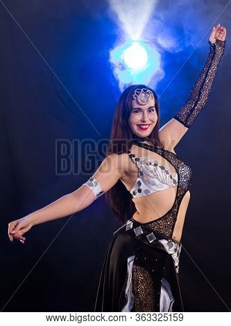 Girl Dancing Belly Dance, Fusion Or Tribal. A Woman In A Beautiful Costume Demonstrates Charming And