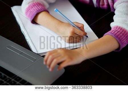 Unrecognizable Schoolgirl Studying At Home With A Notebook And Doing School Homework.