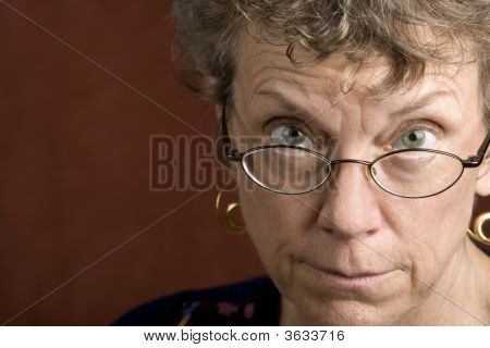Donna che guarda sopra gli occhiali